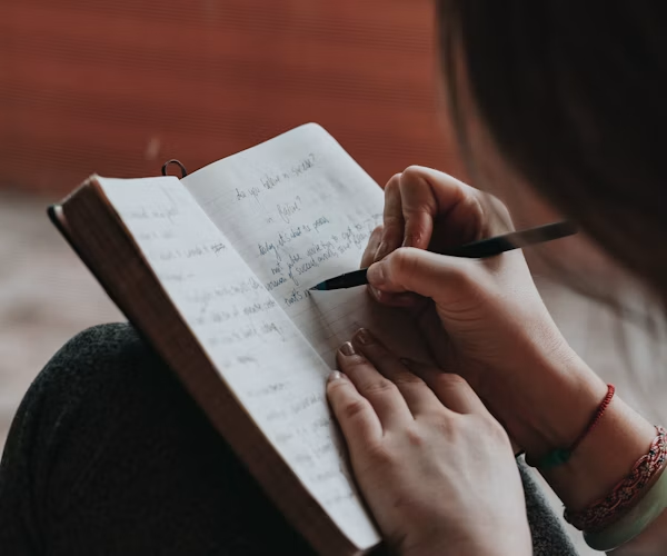 An author writing in a notebook